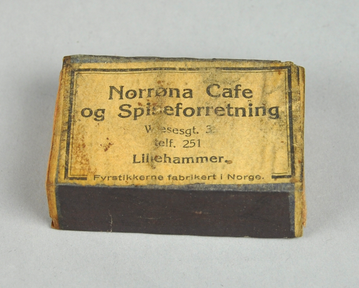 Fyrstikkeske bestående av to deler, en eske som er trukket med rosa papir og kan skyves inn i en annen. På oversiden vises produsentnavnet på et diagonalt bånd med en hest og to mannshoder. På begge sider er det ripeflater. Reklame på baksiden.