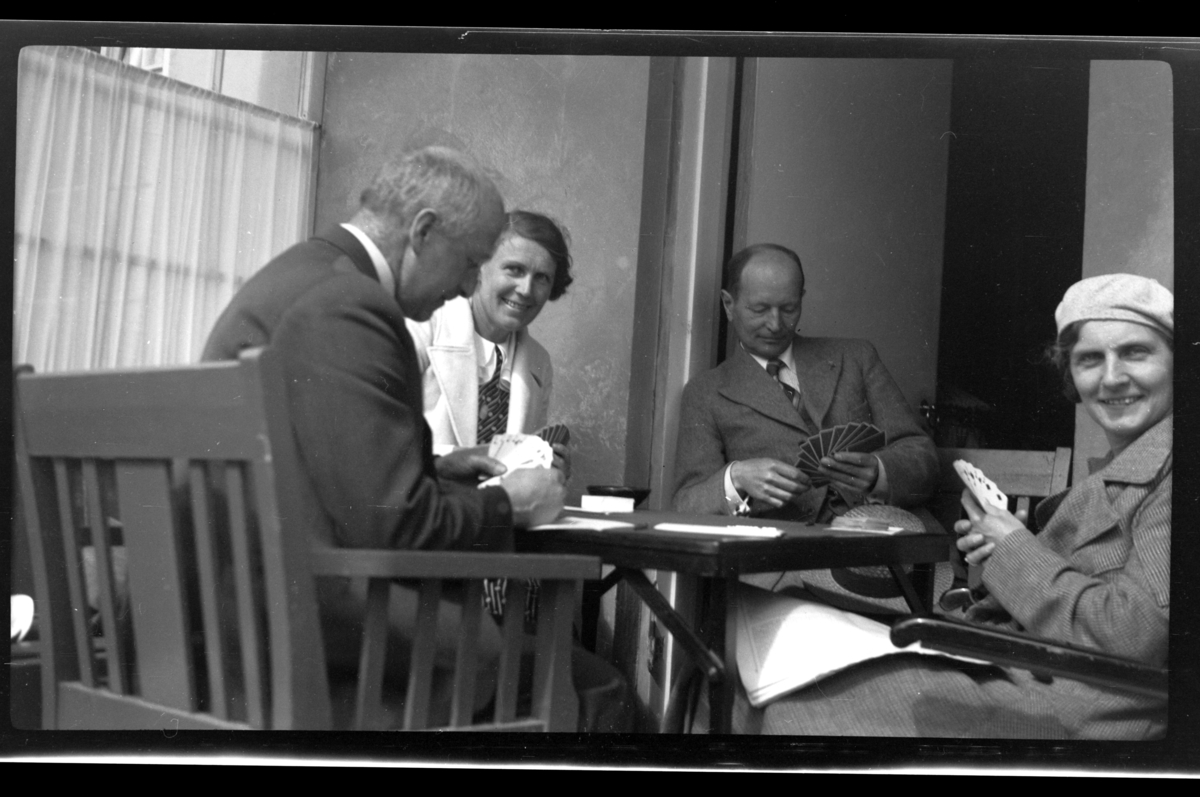 Rolf Sundt sr., Betsy Aubert Hansen, Einar Hansen og Hilda Sundt sitter og spiller kort, Herøya. Fotografert 1936.