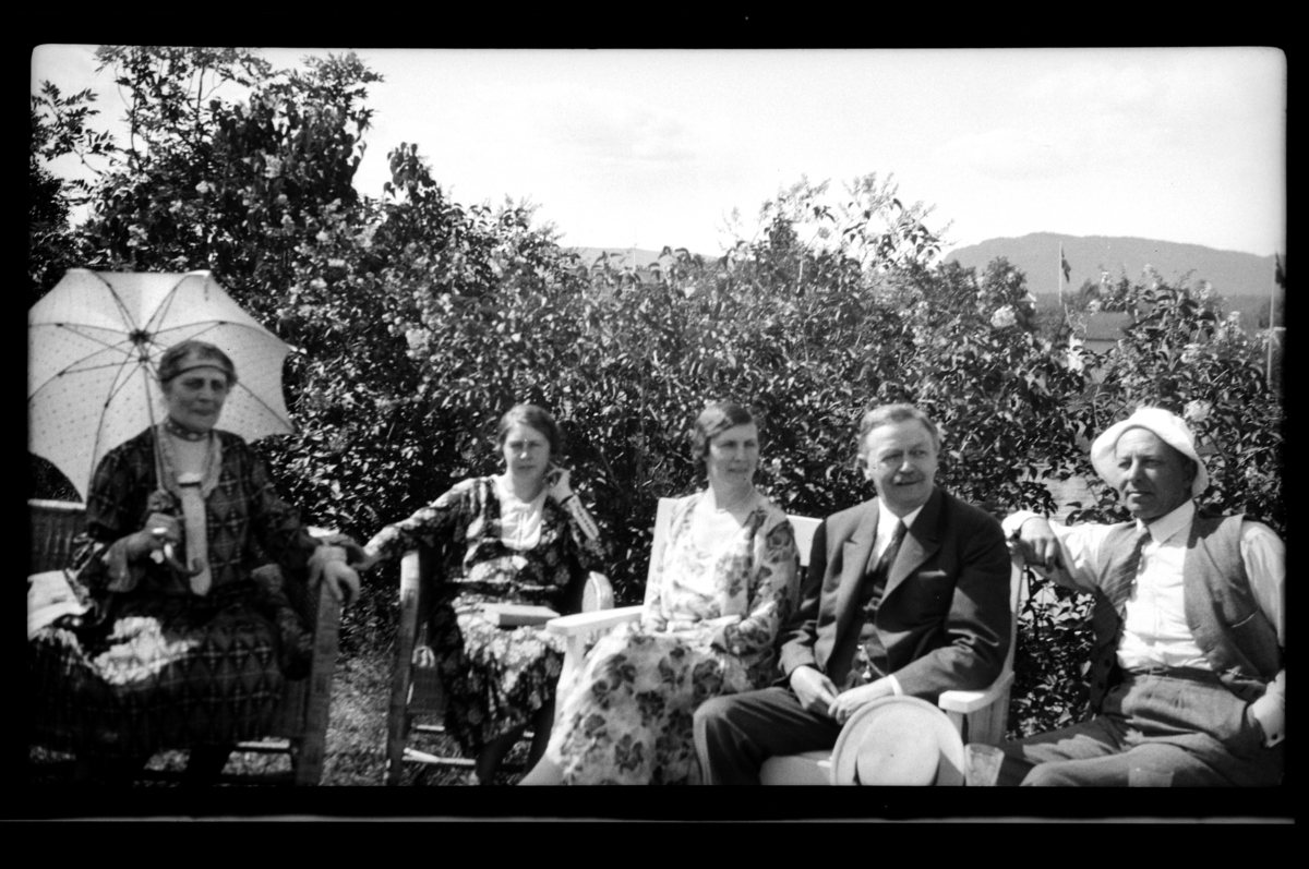 Birgitte Aubert, Birgit Wetterstad, Hilda Sundt, Julius Thaulow Aubert og Sverre Wetterstad sitter i en hage på Konglungen. Fotografert 1930.