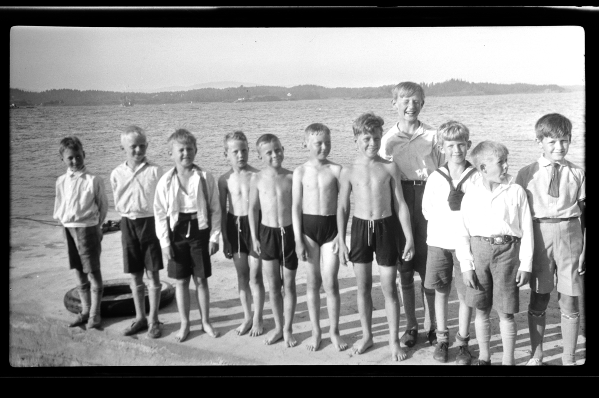 Rolf Sundt fyller 9 år, han står sammen med sin bror Julius, de står som nr. 3 og 4 fra høyre med mange andre gutter på en brygge ved Konglungen. Fotografert 24. juni 1930.