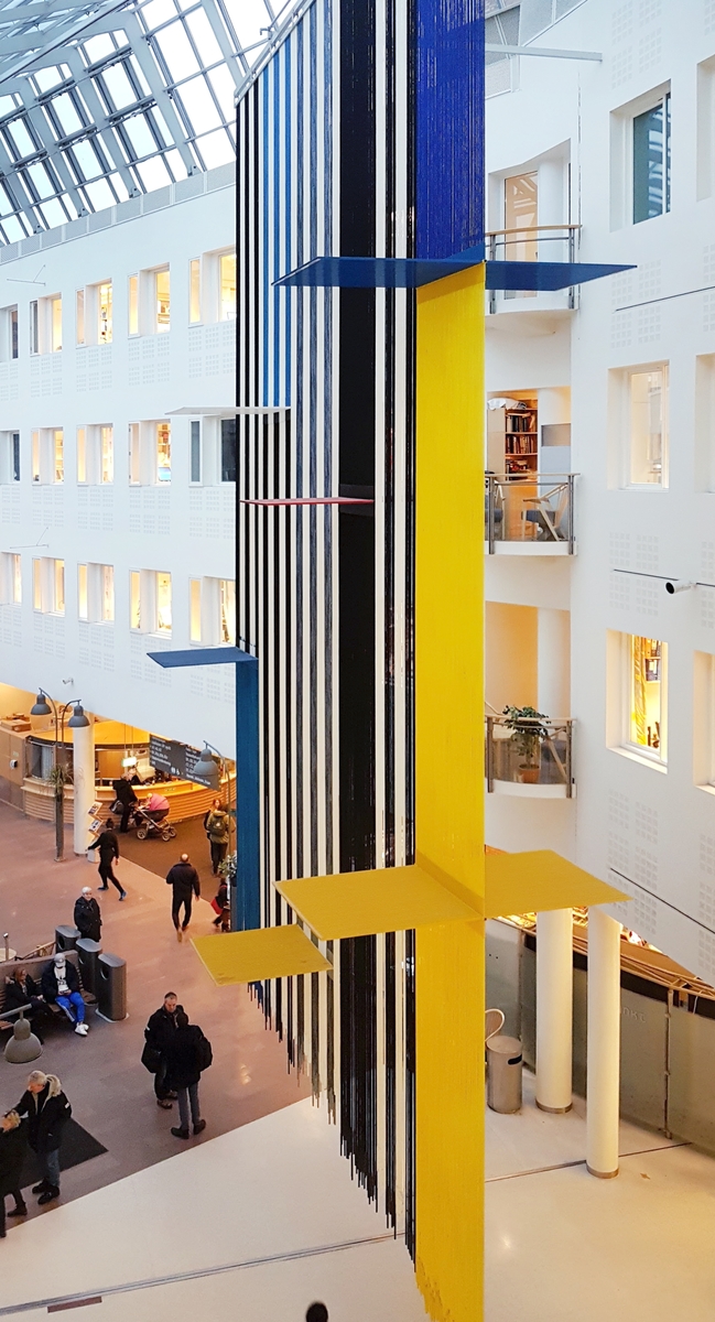 Vestibylen er det sentrale møtestedet og knutepunktet i sykehuset. Her mottas pasienter og besøkende, og ledes videre inn i sykehusets overordnede trafikksystem med glassoverdekte gater, plasser og torg. Et blikkfang i vestibylen er Gunvaldsens store, transparente tekstilarbeid "Balanse" som henger ned fra taket. Teppet er en aktiv aksent i rommet, det er i harmoni med arkitekturen, og det har spennende skiftninger i form og fargespill- alt etter hvilket utsiktspunkt betrakteren har. Verket er synlig fra lang avstand både fra sør og nord i glassgaten, og fungerer slik også som et kunstnerisk "skilt" og en markering av vestibyleområdet.