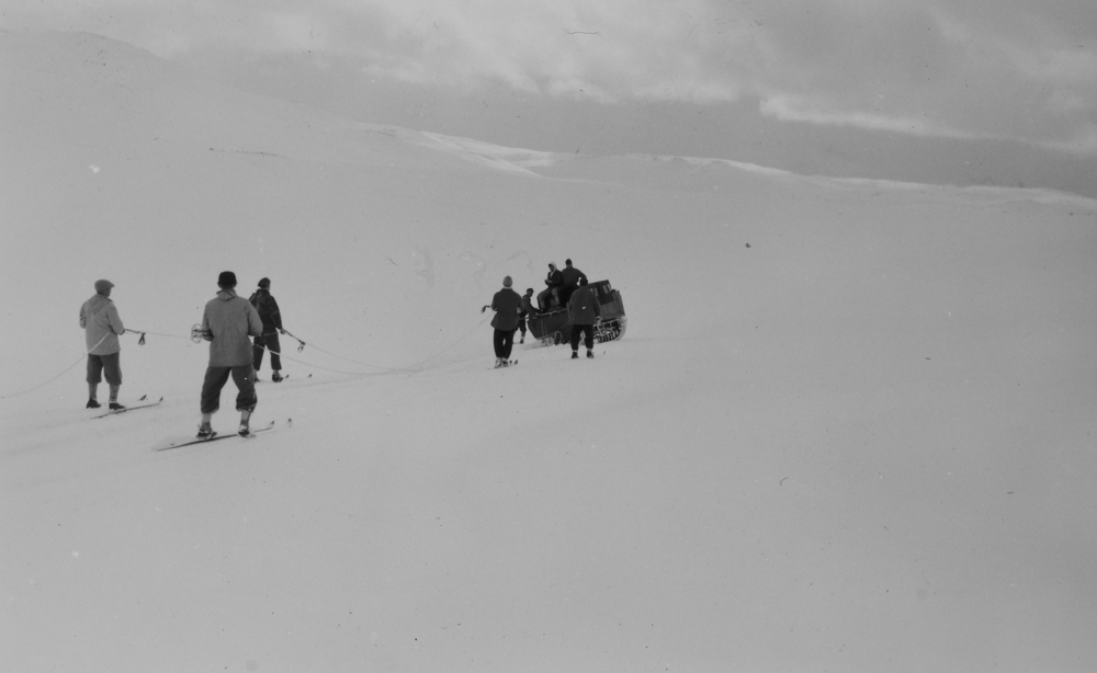 Menn med beltevogner og ski på Børgefjell. Muligens "Jeger og fisk" som skal grave frem hytte fra snøen.