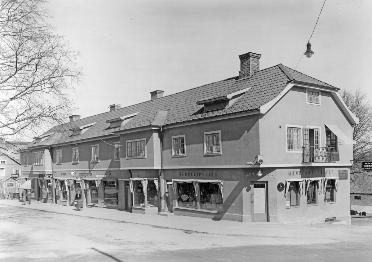 Vy mot Järnvägsgatan 2 i Åtvidaberg. Vid tiden drev bland andra Einar Ekström sin ateljé och fotomagasin och Simon Johansson manufaktur- och herrekiperingsaffär i butiksplanet. Den sistnämnda rörelsen fungerade som filial till Axel Karlsson & Co i Linköping.