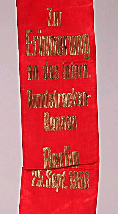 Röd vimpel av konstsiden med guldtext: "Zur Erinnerung an das intern. Rundstrecken-Rennen Berlin 25. Sept. 1956".