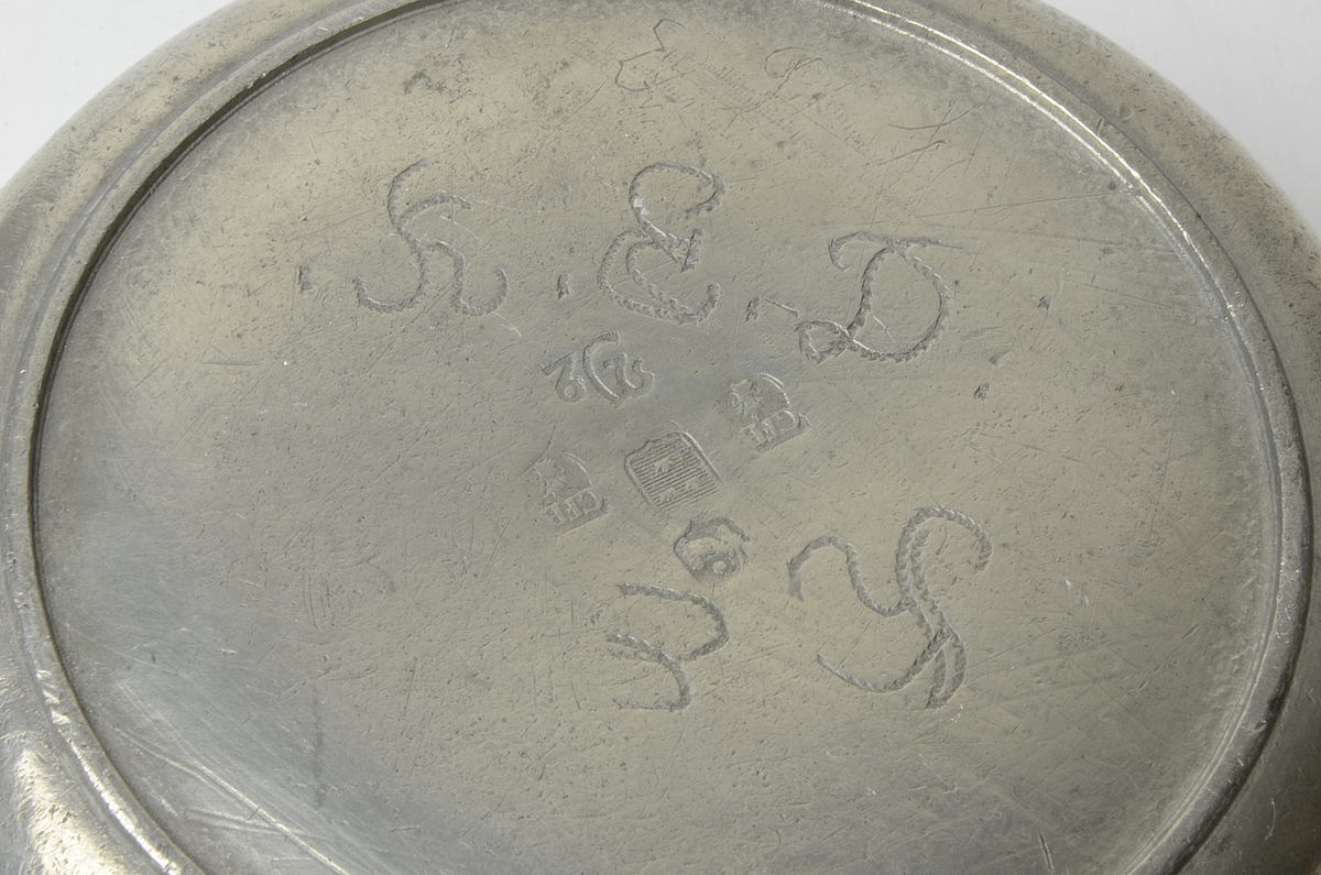 Skål av tenn med handtag i form av snäcka och godronnerad ring.