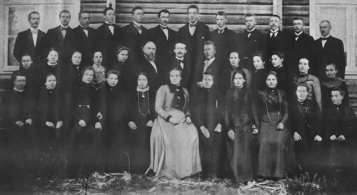 Sangkor på Sand ved århundreskiftet. Bak f.v.: Ole Lund, Artur Svenneby, Anders Dagfinrud, Jakob Ilbråten, Bernt Bunes, Anders Drøserud, Reinhart Svenneby, Karl Christoffersen, Olaf Bunes, Olaf Dagfinrud, Albert Svennebyhagen, Jacob Gravli. Andre rekke f.v.: Signe og Magnhild Hoel, en ukjent, Inga Christoffersen, Lars Anton Hoel, lærer Dybli, Lars Gjerdås, Karen Stenerud, Thora Christoffersen, en ukjent, Anne Stenerud, Marte Drøserud. Foran f.v.: Marte Trøften, tre jenter fra Ekornhol, Anne Heier, Matea Rovelstad, Marie Dagfinrud, en fra Skarnes-Bunes, Marie Rudsbråten, en ukjent, Gorine Føsker.