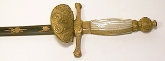 Värja, förgyllt, ciselerat fäste med pärlemobeläggning å kaveln, klingan etsad, delvis blånad och förgylld.