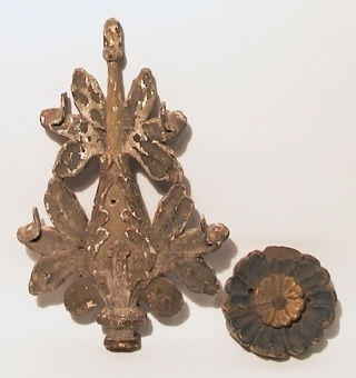 Ett snidat ornament i form av en blomma, blå- och vitmålat samt förgyllt med två hål för fastsättning. Ett genombrutet, snidat ornament, målat grönt med spår av förgyllning.
