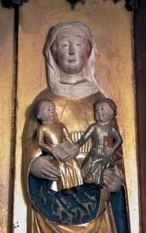Altarskåp. Skåpets motiv är Den heliga släkten med de tre Mariorna i halvskulptur. 

I mitten sitter en krönt jungfru Maria på tron med Jesusbarnet på knät. till vänster står Maria Kleofas, med sönerna Judas Taddeus, Barnabas, Simon och Jacob den yngre. Till höger står Maria Salome, med sönerna Johannes och jacob den äldre. I medaljonger under sockeln återges kvinnornas respektive män: Josef, Kleofas och Salome. 

Mittskulpturen är krönt och frontalt sittande på tron med grön kudde. Manteln är förgylld med blå insida över en förgylld tunika. Kronan har tinnar och fyra blomformade applikationer. Karnationen är ljus med röda kindrosor och håret brunt. Skorna röda och marksockeln är grön. Barnet sitter på högerknät med ett röd-grönt äpple i handen och är vänt åt sidan. Klädedräkten är försilvrad. 

Den vänstra skulpturen är frontalt stående med ett barn på varje arm och två vid fötterna. Manteln är förgylld med blå insida över förgylld tunika med hermelinmönstrad kant nertill. Vit turban över vitt dok och vitt halslinning. Skon är röd. Marksockeln är grön. Ett barn är naket med äpple i handen och ett barn har röd mantel. Två barn har förgyllda klädedräkter med röda böcker.

Den högra skulpturen är frontalt stående med ett barn på varje arm. Manteln är förgylld med blå insida över en förgylld tunika med hermelinmönstrad kant. Skon är röd. Doket är vitt och halslinningen är vit med ett rött mönster. Ett barn har förgylld tunika med bälte och en uppslagen bok i knät. Det andra barnet har försilvrad tunika och en röd bok.

Skåpets ramverk har en profilerad framkant med bladmetall och blå bemålning. Insidan är röd och utsidan mörkröd liksom sockelns översida. Ryggstycket har en mittnisch, är förgyllt och har glorior ovanför skulpturerna och nertill en röd kant. Masverket är genombrutet och består av krabbor, kölbågar, hängkonsoller och strävpelare som bildar tre nischer över skulpturerna. Gallerverket med tre medaljonger förställer tre frontala halvfigurer skurna i relief med namnvimplar mot en röd bakgrund. Flygeldörrar saknas.