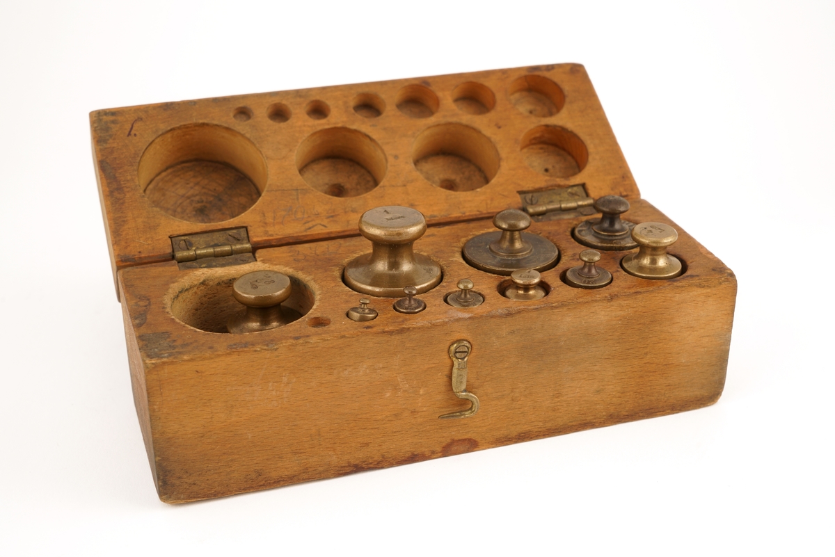 Trekassett inneholdende 10 stk. lodd. Loddene angitt i kg og g.
Loddsamlingen inni er ikke komplett. Seks av loddene er antagelig originale. Fire av loddene har antagelig ikke opprinnelig tilhørt denne esken da de har et annet utseende/annen utforming.