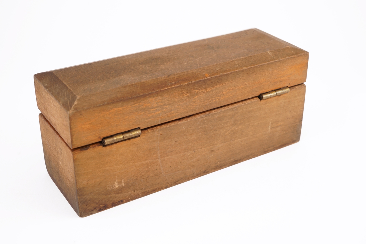 Trekassett inneholdende 10 stk. lodd. Loddene angitt i kg og g.
Loddsamlingen inni er ikke komplett. Seks av loddene er antagelig originale. Fire av loddene har antagelig ikke opprinnelig tilhørt denne esken da de har et annet utseende/annen utforming.