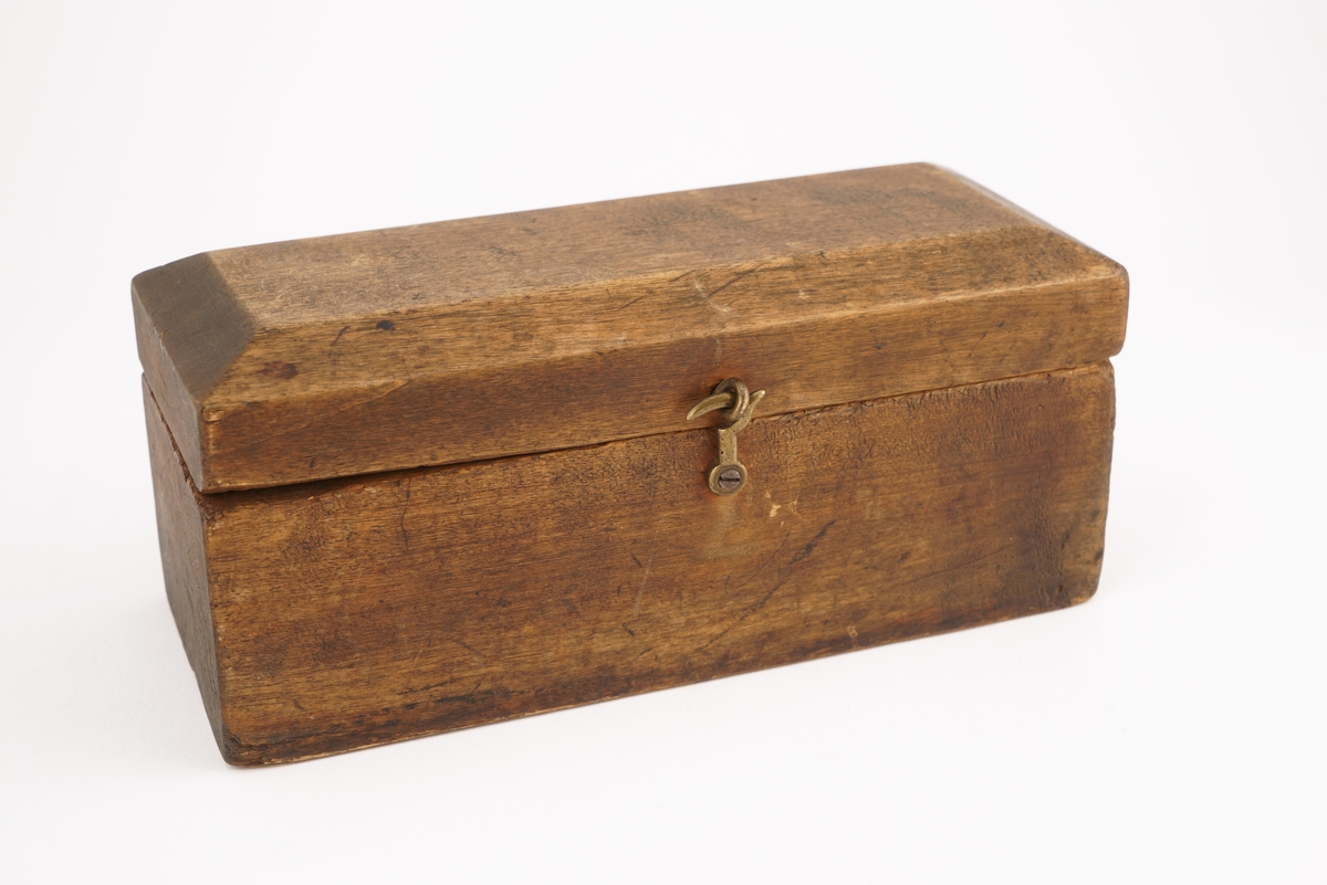 Trekasset inneholdende 5 stk. lodd. Angitt i hg og g.
Det ene hengslet på kassetten er defekt.