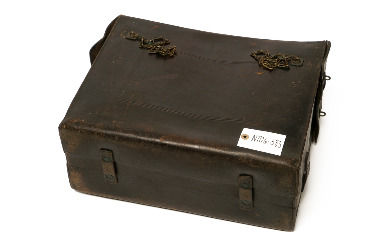 Veske av lær med 9 messingbøyler og to messinglenker for låseanordning. Låsepinne av tre. (Denne ligger i vesken)