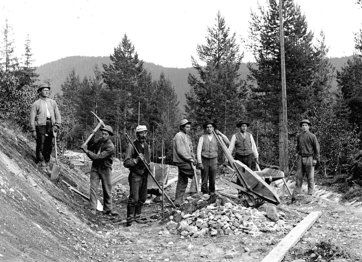Dokumentasjon av arbeid med et veiprosjekt, ant i Trysil. Ukjente arbeidere. Vegbygging. Dessverre har vi ikke fått bekreftet opplysninger om hvilket prosjekt det er, men det kan være fra 1913, og bygging av vegen mellom Nybergsund og Innbygda. Brukerkommentar: Dette er et bilde fra ca. 1897. Personen helt til høyre er Pauli Storveen f.1880 Grøndalen.