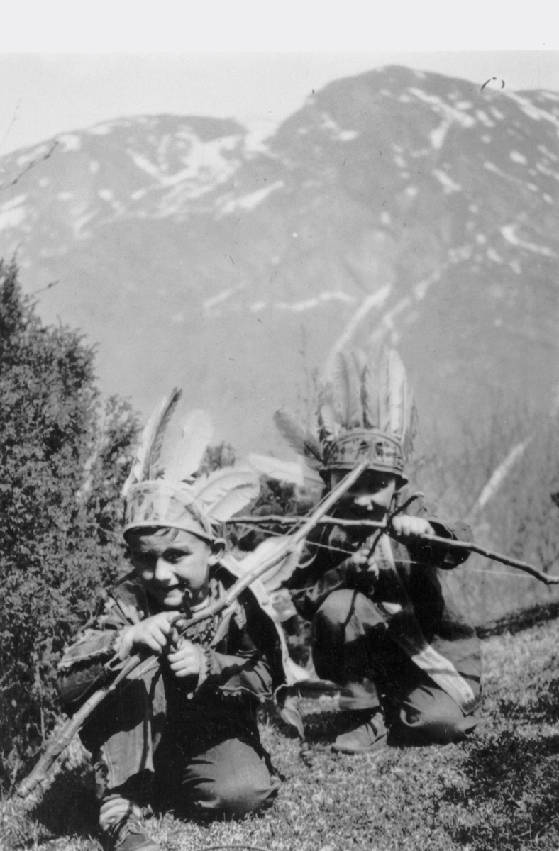 Ivar og Einar Bjørkevoll leker ute i indianardraktar.