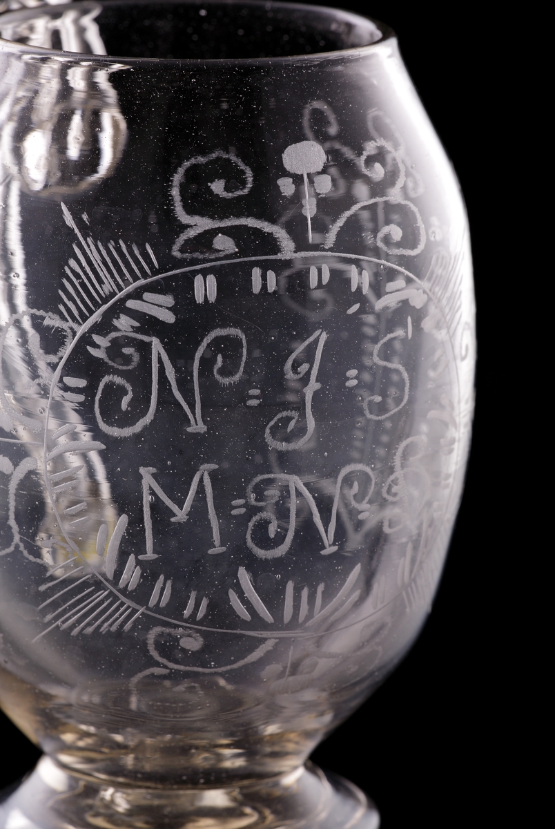 Sejdel av glas, på fot. 
Bukig modell. Graverad blomdekor samt initialerna: "N.J.S,", och "M.N.D.".
Högst troligen ett "giftasglas" som gavs i gåva till brudparet.