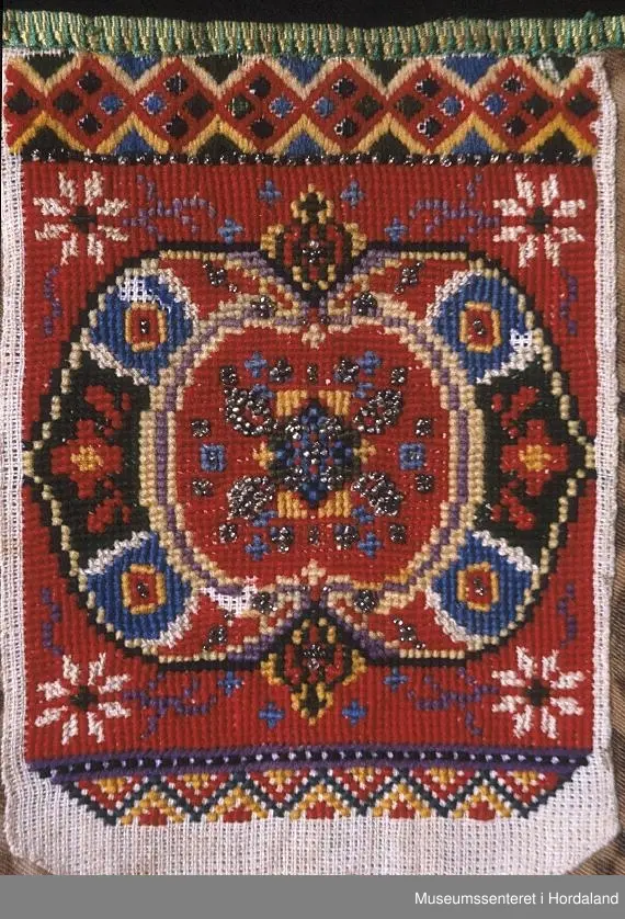 dragesaum øvst, under kvarde, i raudt, grønt.