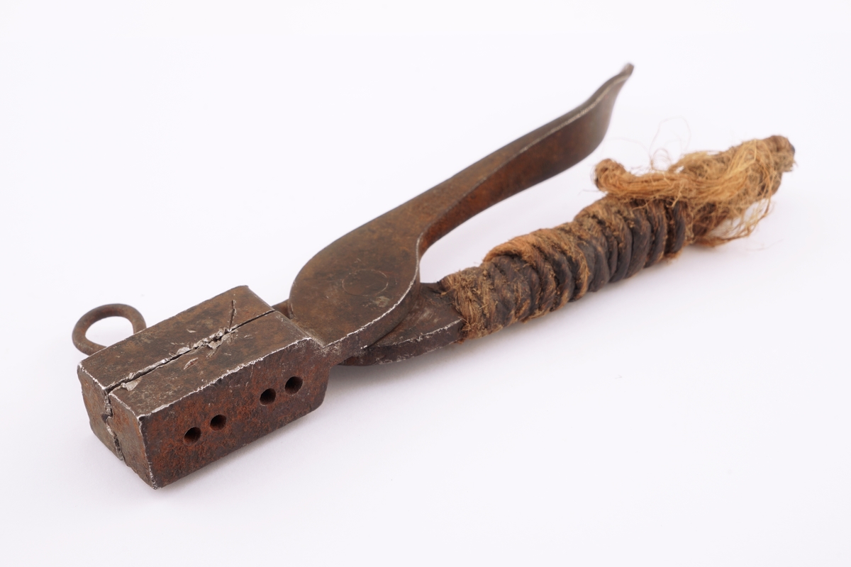 Plombestøpetang for to blomber med en tilhørende pinne og tråd surret rundt håndtak.