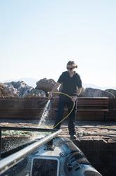 Navigatör spolar av båten i hamn.