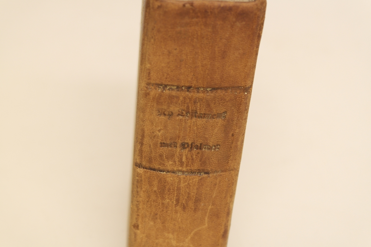 Bok i brunt skinn helbind, med trykte gullbokstaver på ryggen. Stempel trykket på forsiden.