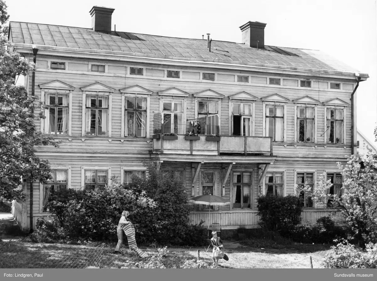 Parkgatan 28. I fönstret Lars Paro, flickan till höger med korgen är hans syster Kerstin, till vänster Monika Ruthberg med en matta.