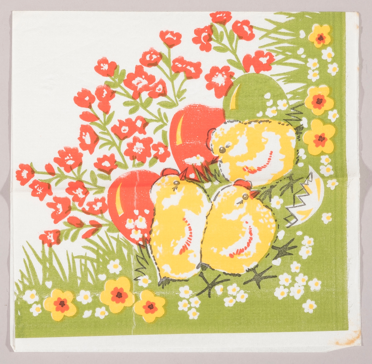 Tre kyllinger i en blomstereng med kulørte påskeegg og et skall fra et egg. Grønt gress med røde, hvite og gule blomster.