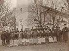 Nattvardsbarn vid Sankt Anna kyrka, det vill säga ungdomar som genomgår konfirmationsundervisning. Mentorn ses till höger, kyrkoherden Gustaf Leonard Lundqvist. Möjligtvis är det den fotointresserade kyrkoherden som själv tagit bilden med hjälp av assistans.