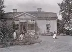 Motiv från Skällviks prästgård Korsnäs. Vid tiden disponerades bostället av kyrkoherde Gustaf Leonard Lundqvist och dennes maka Jacuette, född Ljunglöf. Möjligtvis är det den fotointresserade kyrkoherden som tagit bilden.