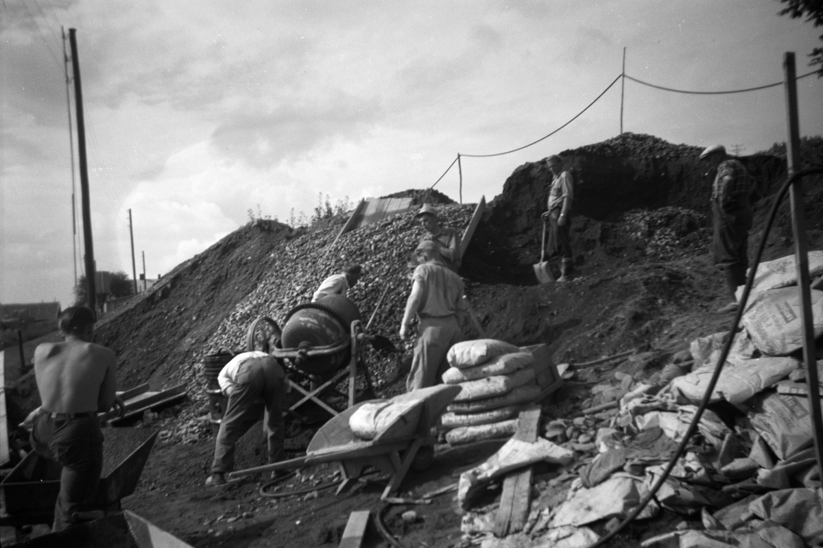 Bygging av ny driftsbygning, Åstad gard, Ring. Sementblander, 7 arbeidere, ukjente. Gnr. 365, bnr. 1-9.