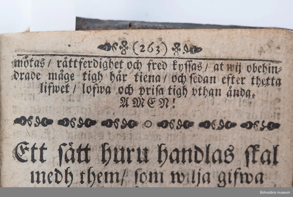 Psalmbok, frakturstil, linnelumppapper, svenska, 403 sidor samt register, duodecimo (12:o). 1695 års psalmbok, 413 psalmer. Trasig.
Samtida helfranskt skinnband med fem lätt upphöjda bind, pärmfyllnad av trä. Skinnet präglat i dekorativt mönster, liknande på fram- och baksida. Dekortivt ramverk, i övrigt heltäckande dekor med textband på mitten, oläsligt. 
Denna slags inbindning användes gärna då psalmboken skänktes som trolovningsgåva.
Rester av två bokpärmsbeslag; fragmentariska skinnband och metallspänne på det nedre. Främre pärmen lagad längs del av de båda kortsidorna med hamrat kopparband, bakre pärmen har hamrat kopparband nertill på kortsidan.
På första sidan handanteckning med uppgifter om ägare och årtalet 1735.

Psalmboken sammanbunden med evangelie- och epistelbok; Evangelia och epistler, 274 sidor.
Cib