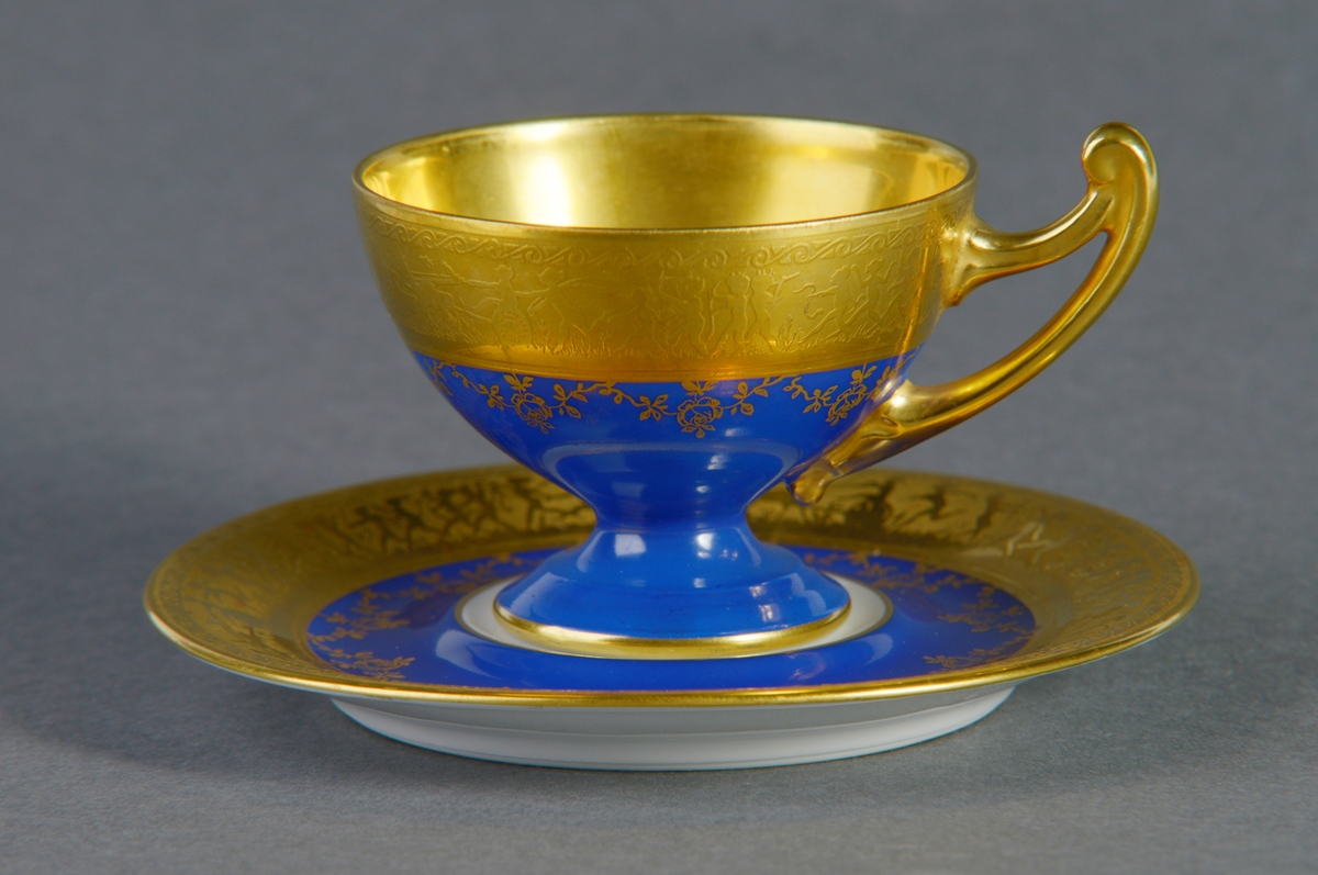 Gullkanten øverst på korpus er dekorert med en scene hvor mennesker danser, løper med dyr, rir, sykler og spiller på instrument. Under denne kanten er koppen dekorert med rose- og bladmønster i gullfarge over det kulørte.