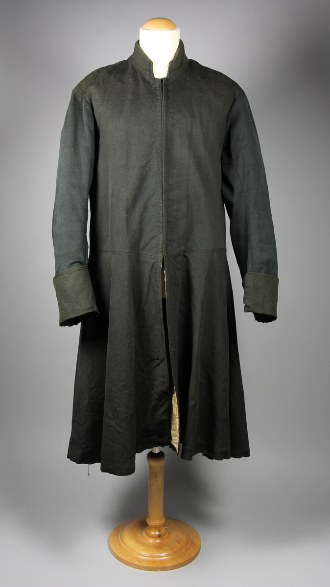 Rock av svart tuskaftsvävt yllekläde. Rocken har en 3,5 cm hög ståkrage. Ärmarna har två längsgående sömmar och 11 cm breda uppslag. Ryggstycket är sammanfogat av fyra våder. Vid axlarna är en trekantig kil infälld på var sida. Troligen en besparing. I höfthöjd har rocken en mittsöm som löper hela vägen runt. Skörten är skurna med stort omfång och rundade. I mitten bak är båda skörten förlängda med en remsa som överlappar på höger sida i ett sprund. Nederkanten har på flera ställen infälda stycken, troligen för att utnyttja tyget maximalt eller som lagningar. Rocken stängs fram med 9 par hyskor och hakar av grov mässingstråd.

Fodret är sytt av minst tre olika tyger. Överst ett grövre grårandigt linnetyg med två infällda innerfickor. Ärmarna är fodrade med oblekt linne och har vaddering av bomullsvadd. Nederst i båda ärmsluten finns rester av blåfärgade linneremsor. Kanske ett tidigare fodertyg eller ett mellanlägg. Rockens nedre foderdel är av ett tunt linne eller bomullstyg med tryckt mönster i brunt på ljusbrun botten. Möjligen är den övre delen av fodret yngre än den nedre. Slitaget på den övre är mindre än på de nedre. Hela rocken är handsydd, men det förekommer lagningar och bättringar med raksöm från symaskin. Det finns flera mindre och några större hål samt sömmar som släppt.