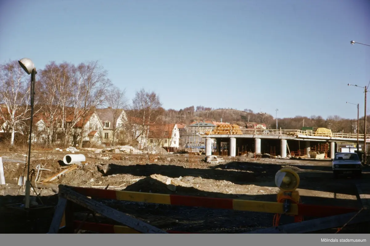 Vy från Broslättsgatan i Mölndal mot byggnationen av nya Mölndals Bro, ca 1974-1975.
