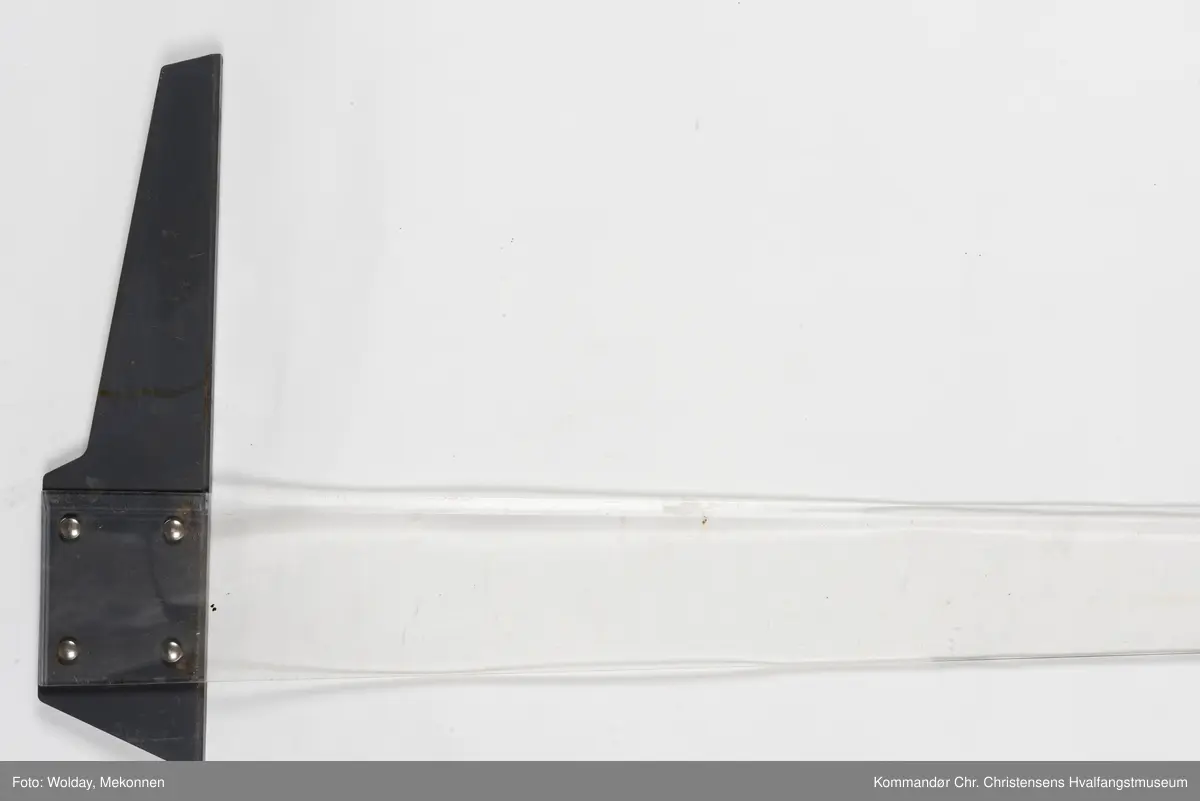 Form: T-form, lang linjal med cm-skala. Rundt hull i enden