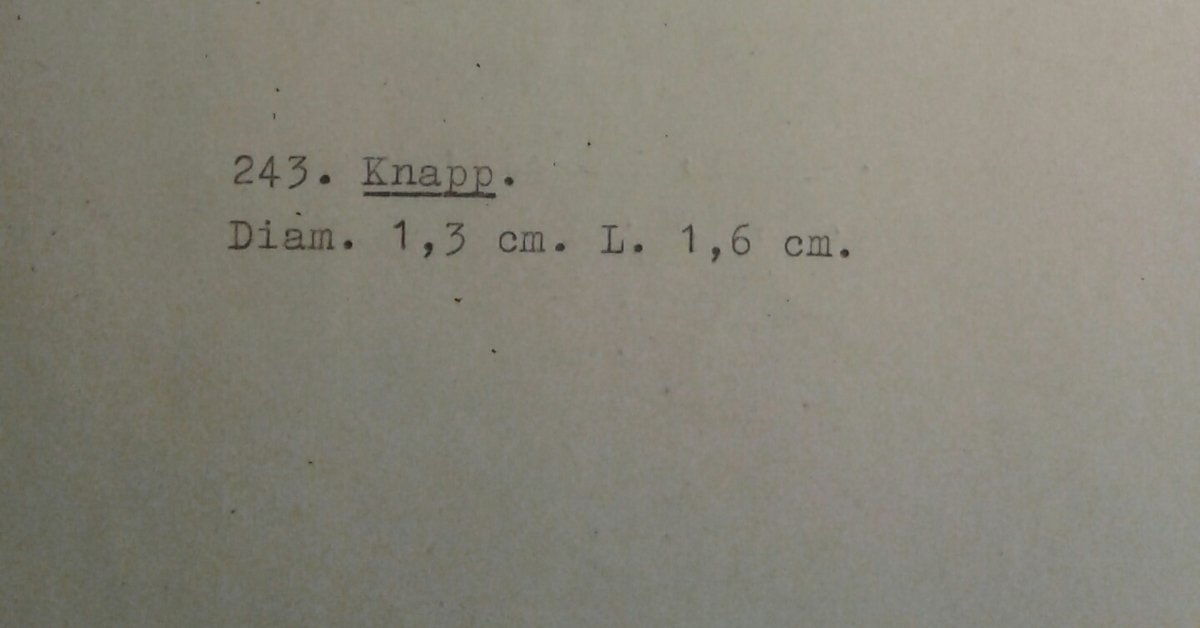 Halvsfärisk knapp av tenn med oval ögla.