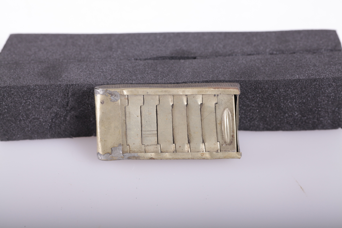 Esken har leddet skyvelokk som forsvinner i den dobbelte bunn, riveflate på den ene siden