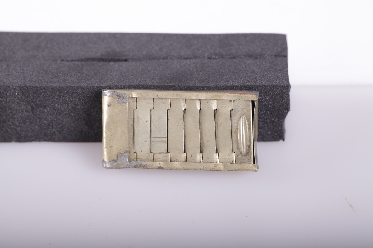 Esken har leddet skyvelokk som forsvinner i den dobbelte bunn, riveflate på den ene siden