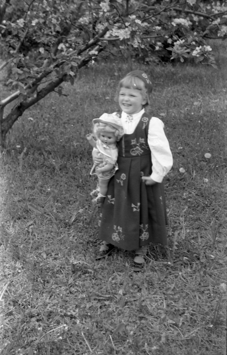 Serie på 11 helfigurs portretter av Dagmar og Michael Nordrum med dattera Else Marie mot en bakgrunn av et blomstrende frukttre. Noen av bildene er av de tre sammen, noen av mor og datter som begge bærer bunad, og noen av Else Marie alene.