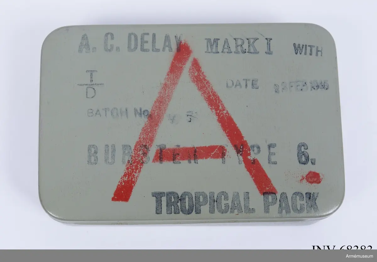 Grå plåtlåda med 6 ampuller innehållande acetonlösningar för olika tidsutlösningar.
Burster type 6.

A.C. Delay Mark I, TROPICAL PACK, Utlösare till fästmina:

With T/D Batch no (oläsligt), DATE 23 FEB 1945
BURSTER TYPE 6. TROPICAL PACK. A. 

Inklusive tändanordning och 6 st färgampuller med beskrivning. 
Acetone Celluloid
På instruktionen på insidan Type B
Vid 15 grader C fördröjs ampullernas utlösning med:
•	Röd 4 ½ time
•	Orange 7 ½ time
•	Gul 15 timmar
•	Grön 26 timmar
•	Blå 42 timmar
•	Violett 5 ½ dag
Notera att det kan ske en avvikelse på 15 % åt vardera hållet förutom Röd då avvikelsen kan vara 2 timmar åt båda hållen.