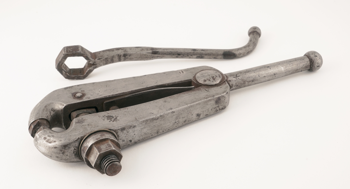 Plomberingstang av metall med skrumekanisme og nøkkel