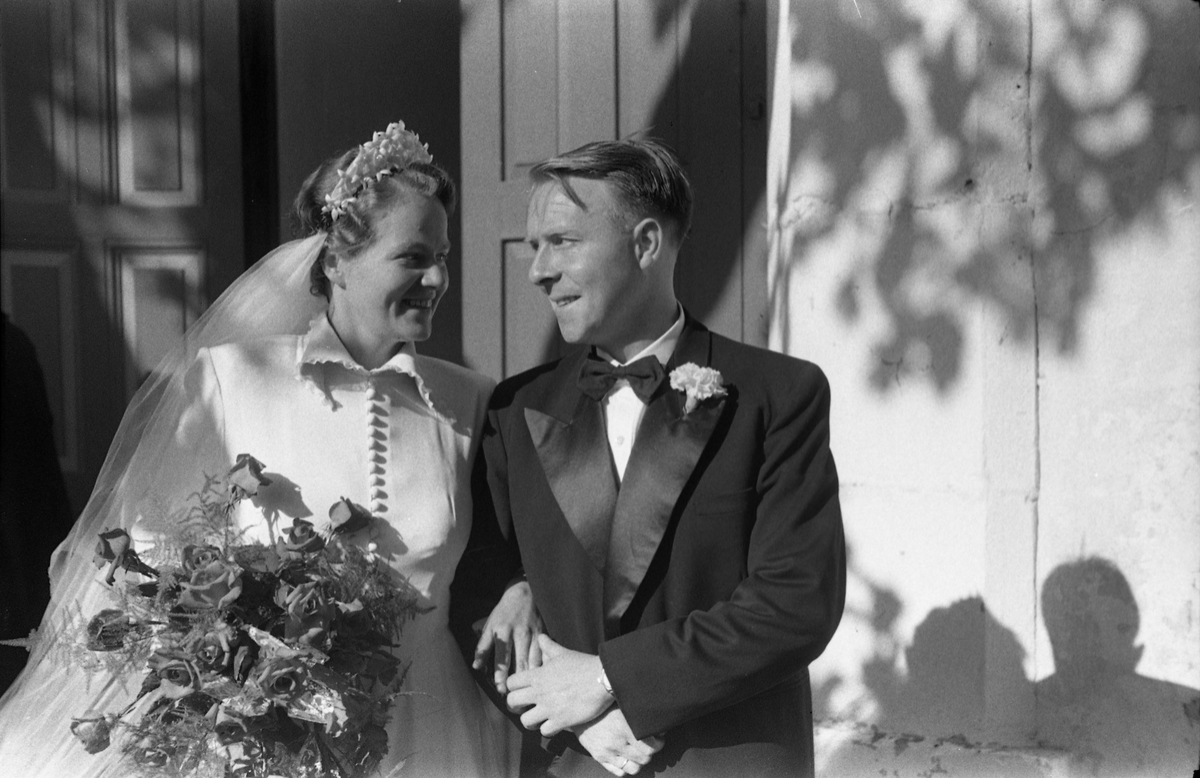 Brudeparet Else Rustad og Edvard Narum fotografert foran inngangen til Hoff kirke. Serie på 11 portretter, noen i helfigur, andre i halvfigur.
