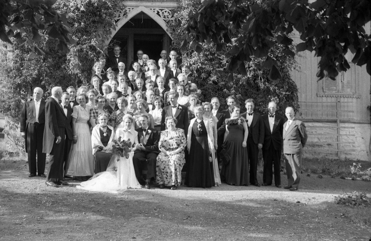 Bryllupsfest på Hoff Gjestgiveri 12.juli 1952. Brudeparet, Else Rustad og Edvard Narum, sammen med gjester fotografert foran gjestgiveriets hovedinngang. Til høyre for brudgommen sitter hans mor, Signe Narum. Til venstre for bruden hennes mor Betsy Marie Rustad, og til venstre for henne Kari "Mosse" Larsen (f.Rustad). Bak henne igjen står hennes mann Ernst Larsen (m/tversoversløyfe). Lengst til venstre står muligens Hans Rognerud. Fire bilder.