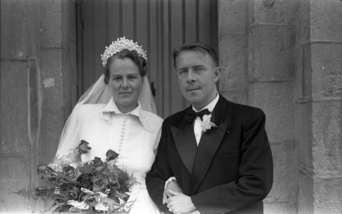 Brudeparet Else Rustad og Edvard Narum fotografert foran inngangen til Hoff kirke. Serie på 11 portretter, noen i helfigur, andre i halvfigur.