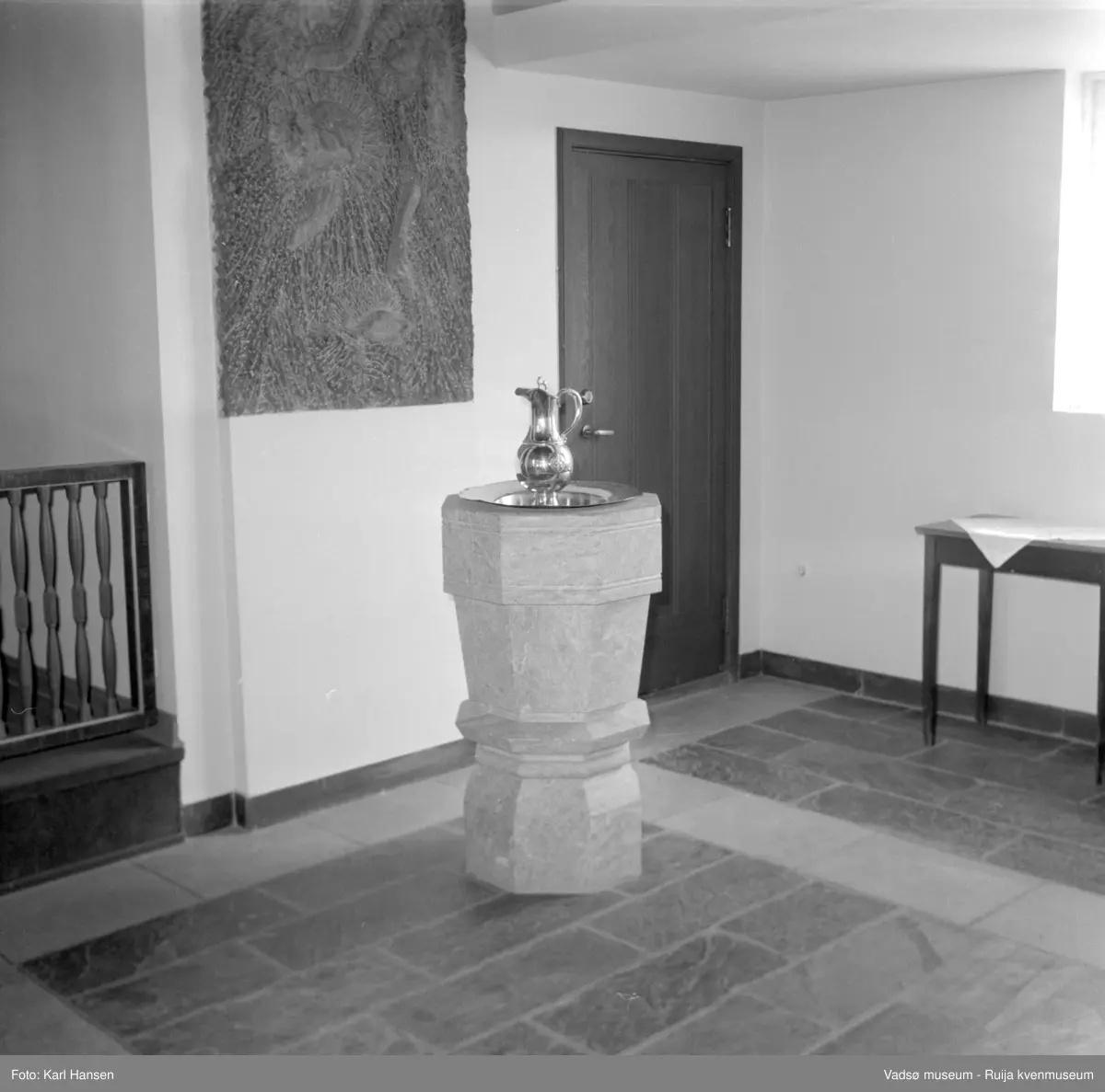 Vadsø kirke 7.5.1969. Interiør, døpefonten. Vadsø kirke ble vigslet i 1958, tegnet av Magnus Poulsson, utsmykket av Greta Thiis.