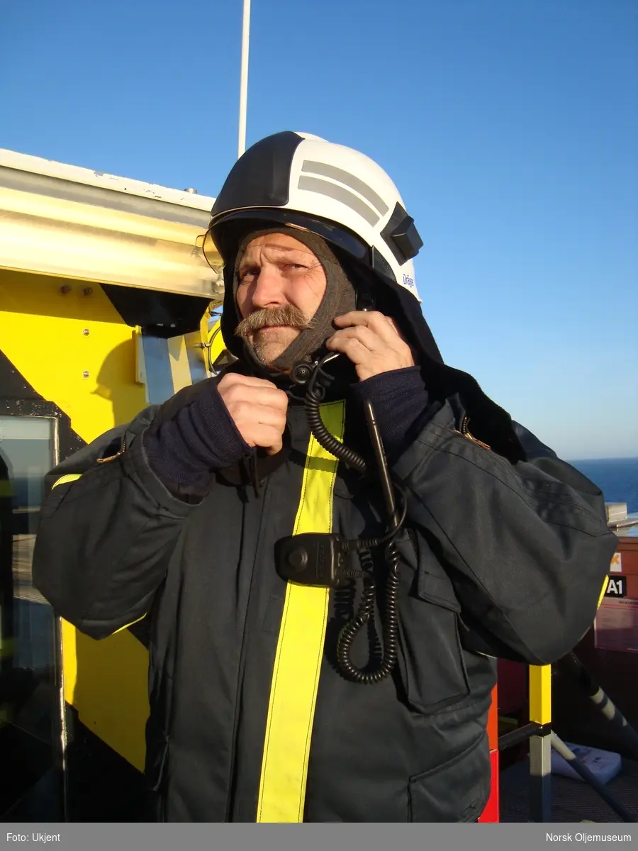 Brannmann gjør seg klar for å være i beredskap ved landing og take-off av helikopter på Draugen.