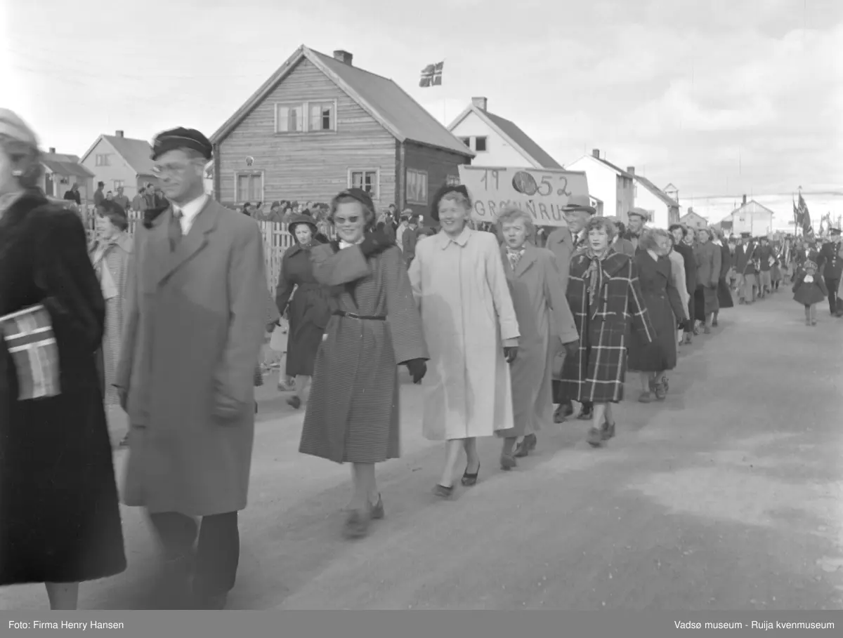 Vadsø 17 mai 1952. 17.mai-toget går gjennom Oscarsgate fra øst mot vest. Åssiden Melkevarden sees i bakgrunnen. Grønnruss.