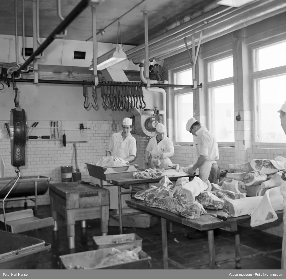 Nord-Norges salgslag Vadsø, 1964. Tre menn skjærer/parterer gris i Skjæreavdelinga (skjæra). Fra venstre; ukjent, Hans Heiskala og Roy Aronsen.