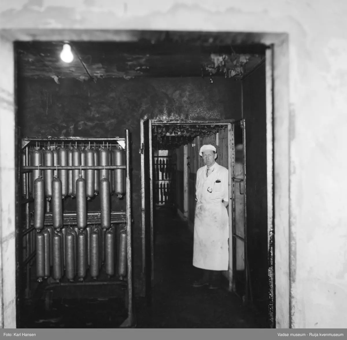 Nord-Norges salgslag Vadsø, 1964. Spekepølser i røykeri/klimarom . Avbildet person; produksjonsleder Hans Petter (HP)  Hansen.