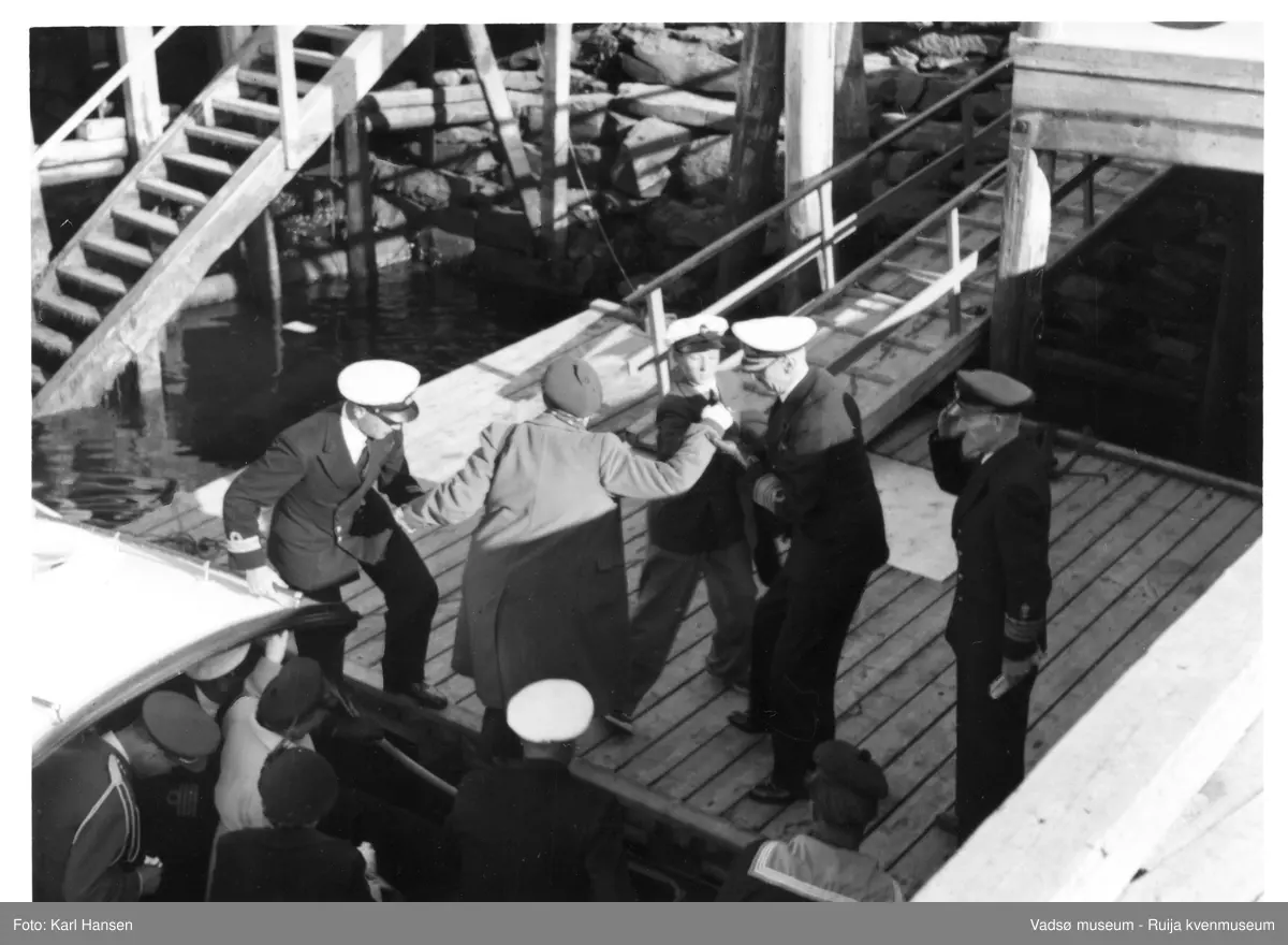 Vadsø. Kongebesøk i Vadsø 1950. Kong Haakon 7. og prins Harald går ned trappa. Kong Haakon og kronprinsfamilien besøkte Vadsø 25.-26.7.1950 i forbindelse med en større rundreise i Nord-Norge sommeren 1950. Under besøket sto "biltur gjennom byen" og "besøk på sykehuset" på programmet. Kilde: Det kongelige hoff, arkivet