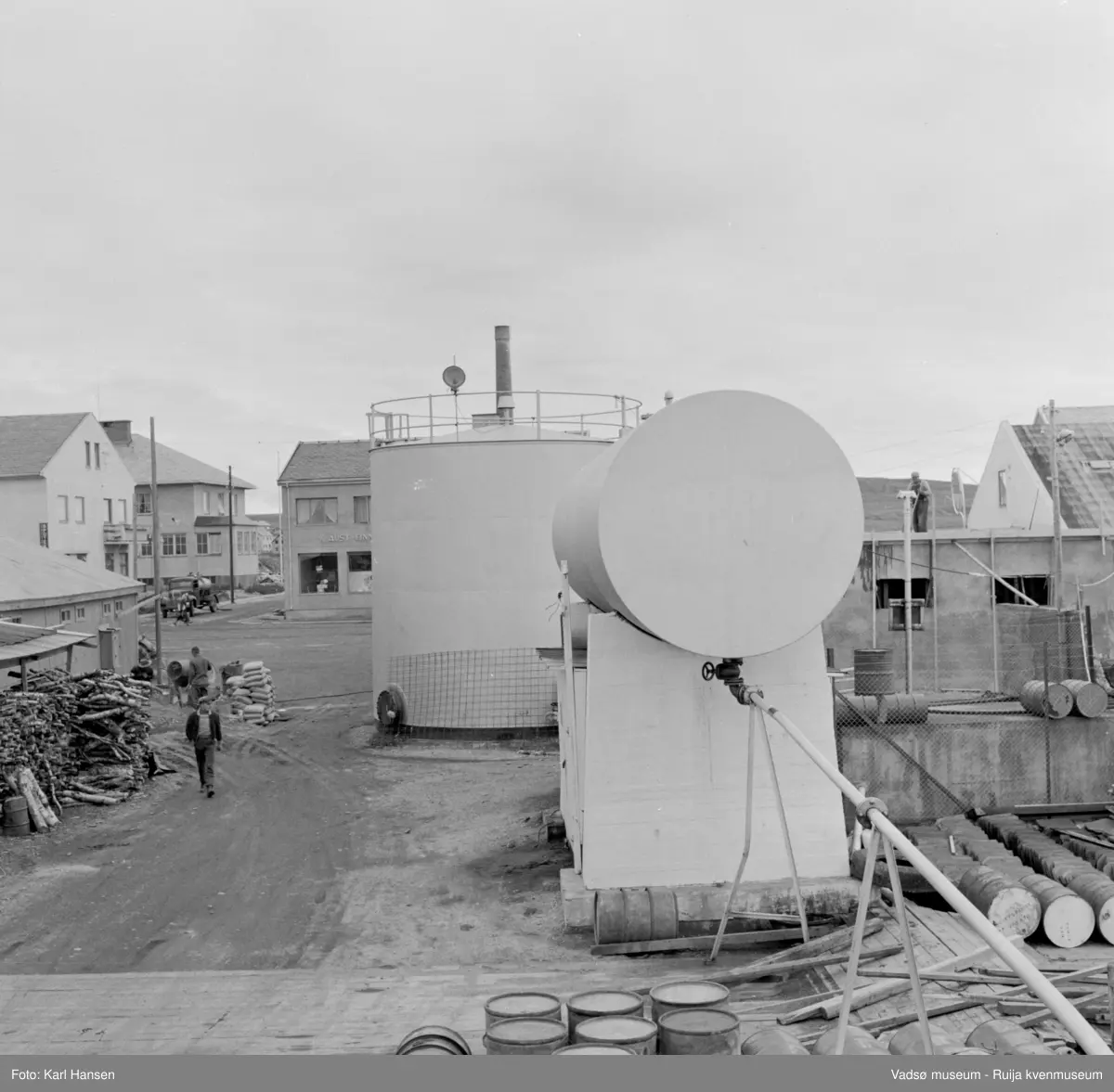 Vadsø sentrum 1959. Shells tankanlegg for drivstoff i forgrunnen. Kryss Tollbugata/W.Andersens gt. lenger bak med meieribygget til høyre, H.F. Esbensens forretningsbygg t.v. med Telegrafen bak.
